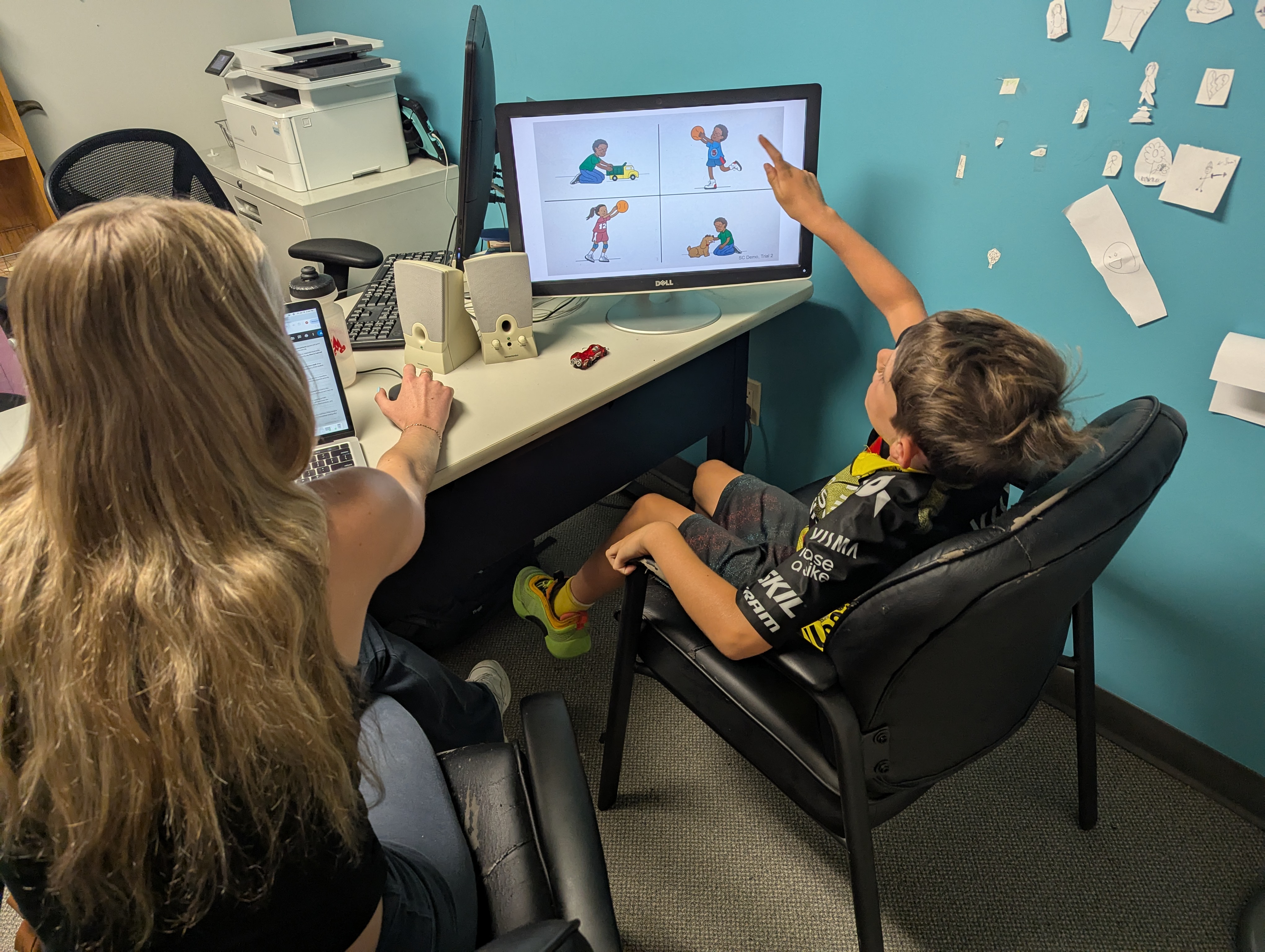 Lab member with patient going over images on a monitor